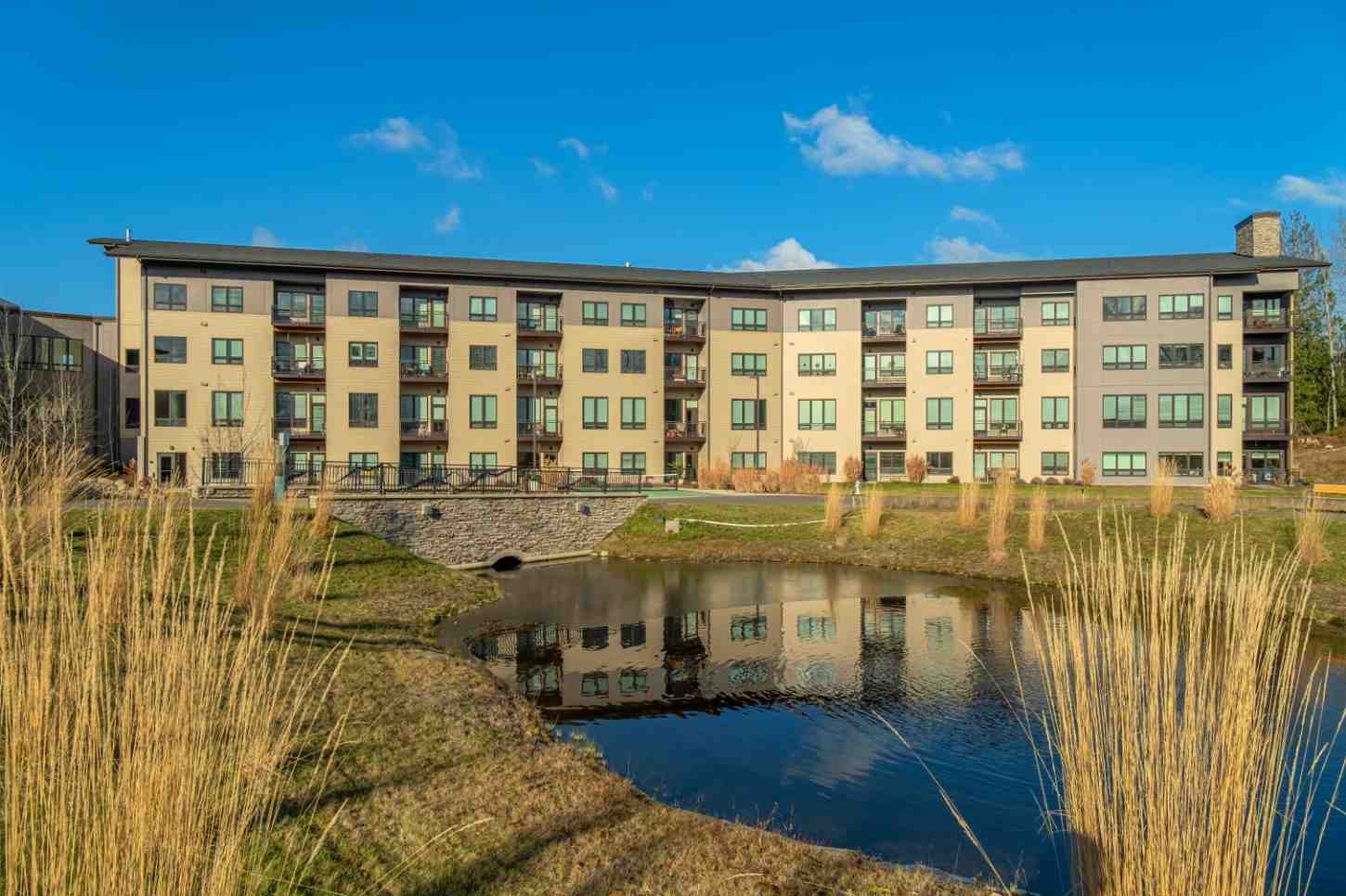 Modern skilled nursing and senior living facility overlooking a pond