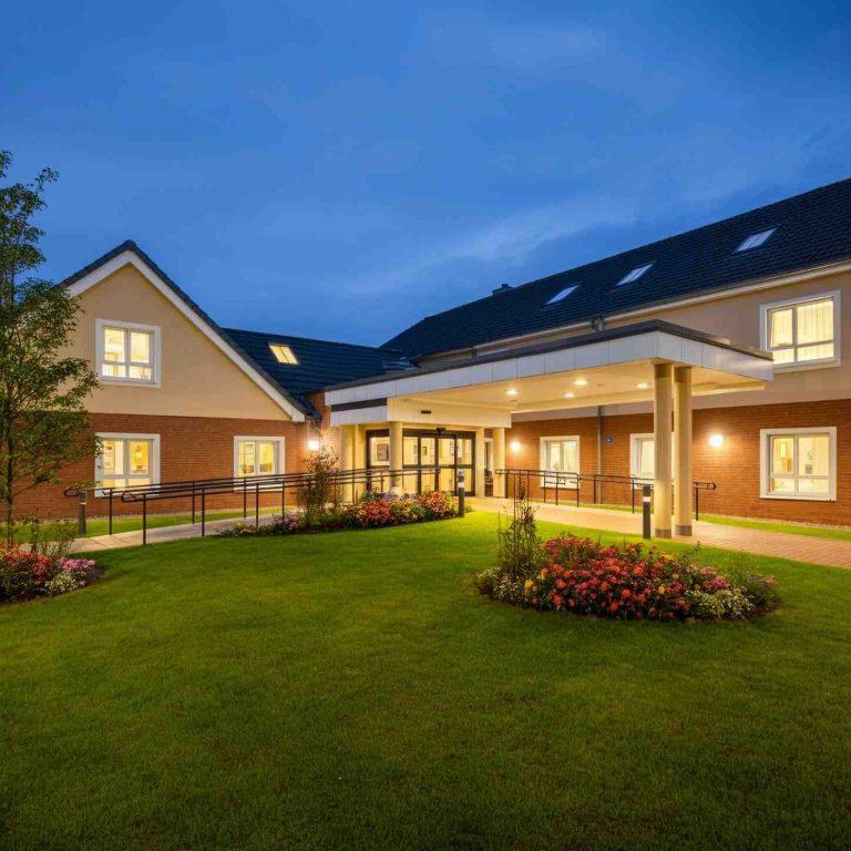 Skilled nursing facility exterior at dusk with warm lighting